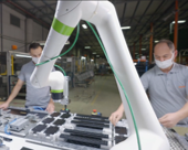人と協働ロボットが協力して部品を組立てている写真