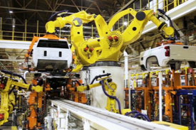 沢山のロボットが車を組み立てている写真